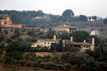 Houses on a hillside among trees. Rural landscape, traditional architecture, and a sense of tranquility.