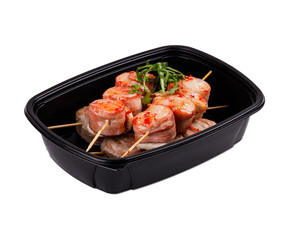 A black plastic container that holds an assortment of meat on skewers
