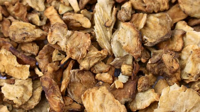 Brown dried chicory root slices circle rotation close up