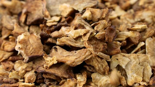 Brown dried chicory root slices falling down close up