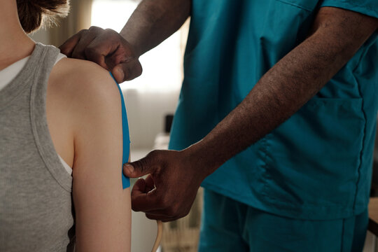Healthcare professional administering vaccination to patient's upper arm in medical setting. Arm of patient wearing sleeveless shirt visible during vaccination procedure
