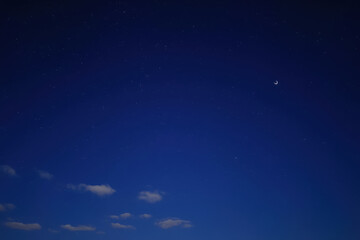 Naklejka premium Celestial Serenity: Moonlit Night Sky with Scattered Stars, moon and Tranquil Atmosphere.