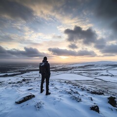 A photographer standing on top of the Yorkshire Dales during winter, golden hour, snow-covered landscape, stunning view, dramatic sky
