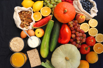 Various healthy fruits, vegetables and cereals on dark background. Top view.