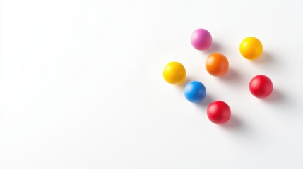 Obraz premium Colorful Toy Marbles Scattered on a White Background for Playful Imagery and Creative Concepts