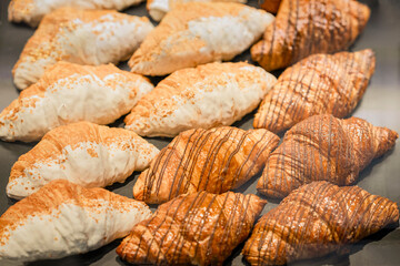 Freshly baked croissants, sweet handmade dessert. Top view of freshly baked croissants with chocolate and white icing. Bakery, pastry, delicious breakfast food