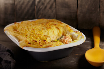 Home made fish pie with a rustic background.