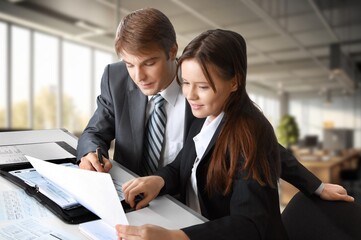 Two happy business people sitting in office.