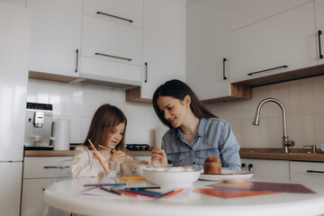 Mother and Daughter Enjoy Arts and Crafts Together in a Kitchen Setting