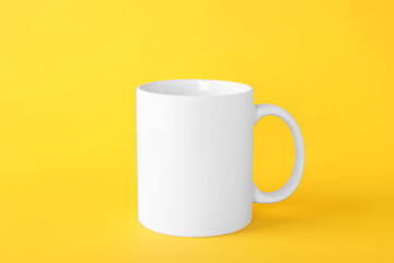 One blank white mug on yellow background. Mockup for design