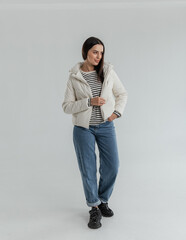 Portrait of a cute girl model in a leather white jacket and striped sweater