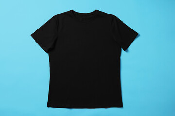 One blank t-shirt on light blue background, top view. Mockup for design