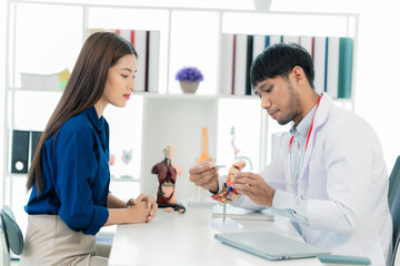 Fototapeta premium A male orthopedist gives advice to female patients and lectures to female patients in the hospital. medical health care