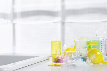 Clean feeding bottles drying on counter indoors. Space for text