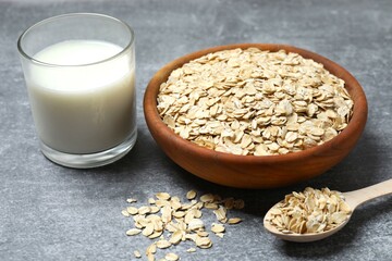Composition with oatmeal flakes on gray background. Cooking breakfast