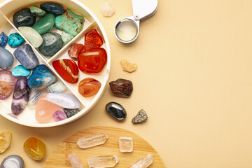 Box with beautiful gemstones on beige background, flat lay. Space for text