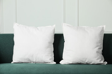 Blank soft pillows on cozy couch indoors