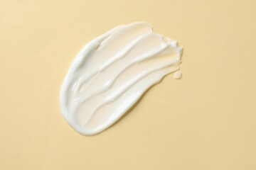 Sample of body cream on beige background, top view