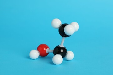 Molecule of ethanol on light blue background. Chemical model