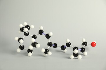 Molecule of retinol (vitamin A) on light grey background. Chemical model