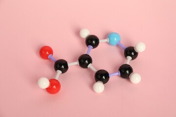 Molecule of niacin (vitamin B3) on pink background. Chemical model