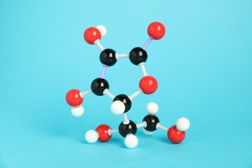Molecule of vitamin C on light blue background. Chemical model