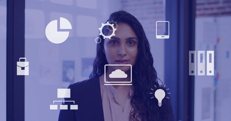 Image of business icons over biracial businesswoman in office