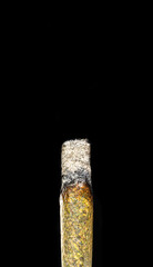 Burning Cannabis Joint – Close-Up Macro Shot on Black Background