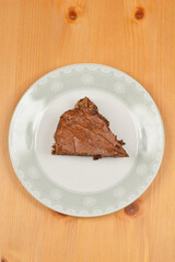 Top-down viwe of slice of homemade chocolate cake presented on a decorative plate