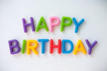 A cheerful Happy Birthday message is spelled out using colorful plastic letters on a white background. The letters are arranged neatly, creating a festive mood.
