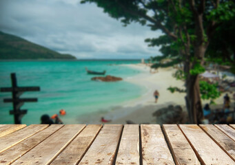 Fototapeta premium Wooden table top on the beach or sea.Party on the beach sunshine time concept.For montage product display or design key visual layout.View of copy space.