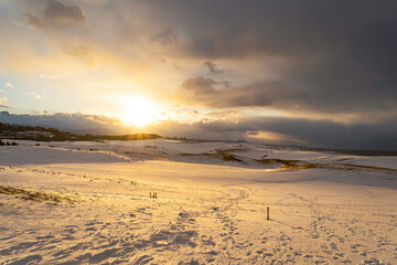 雪の鳥取砂丘の夕日