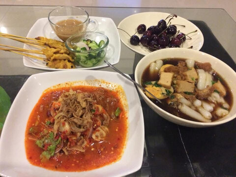 Dining table with multiple dishes for the family, Cherry, Pork satay grilled, spicy salad, kaow jub