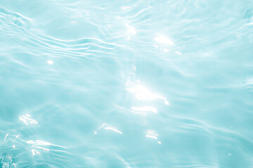 Fototapeta premium Sunlight dances on the surface of serene blue water, creating gentle ripples. This tranquil scene captures the beauty of nature on a warm afternoon.
