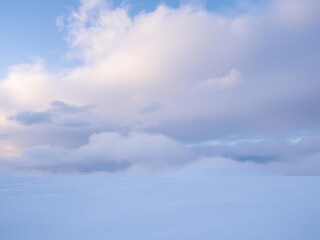 Obraz premium White fluffy clouds floating high in the sky on a windy winter day, creating a serene and peaceful backdrop, atmosphere, season, clouds