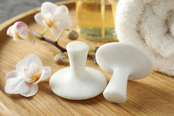 Spa stones, orchid flowers and towel on wooden tray, closeup
