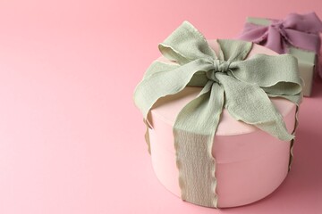 Different gift boxes with beautiful bows on pink background. Space for text