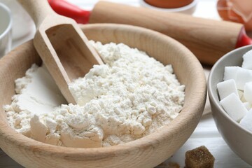 Ingredients for dough and rolling pin on table, closeup