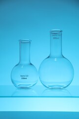 Empty flasks on light blue background. Laboratory equipment