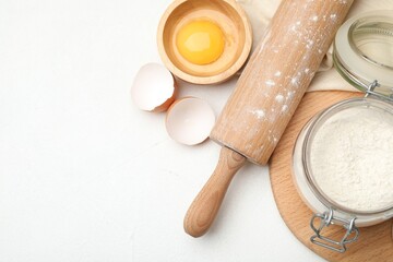 Rolling pin and different ingredients on white table, flat lay. Space for text