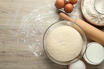Rolling pin and different ingredients on light wooden table, flat lay. Space for text