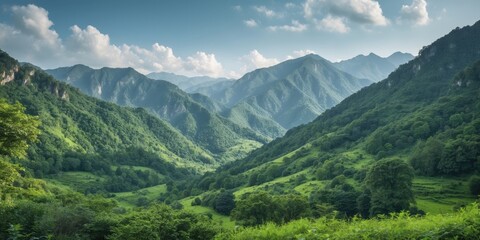 Lush green valley surrounded by mountains under blue sky with clouds providing a panoramic view of nature's landscape.