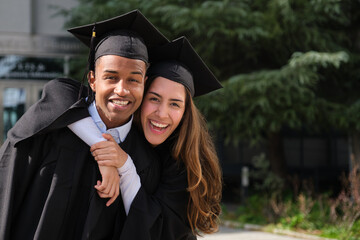 Two graduates celebrating their achievement in caps and gowns