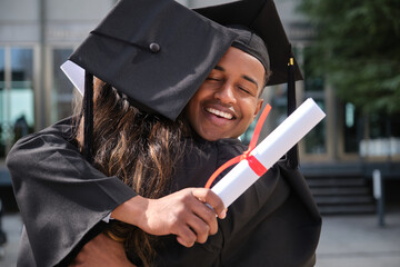 Two graduated students hugging each other, celebrating their achievement