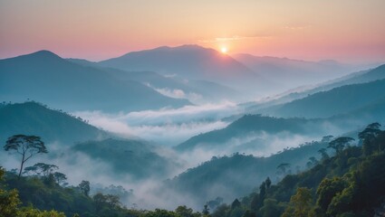 Obraz premium Misty mountain landscape during sunrise with layers of hills and fog in the valley under a colorful sky