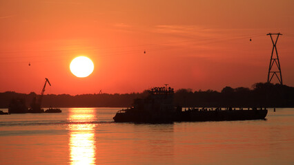 Fototapeta premium Silhouettes of ships on the river at sunset.
