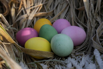 bunte Ostereier im Osternest mit Schnee