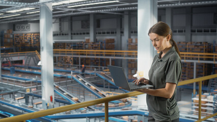 Sortation Fullfilment Center: Female Supervisor Associate Uses Laptop. Logistics, Transportation Warehouse Facility with Conveyor Loading Product Boxes for Online Shoppping Order Delivery to Customers