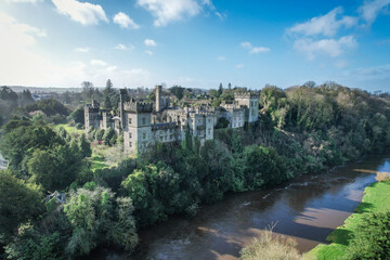 Aerial view of Lismore Castle, Ireland, showcasing its stunning Gothic architecture and scenic riverside location
