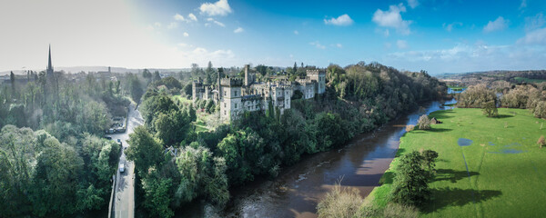 Aerial view of Lismore Castle, Ireland, showcasing its stunning Gothic architecture and scenic riverside location